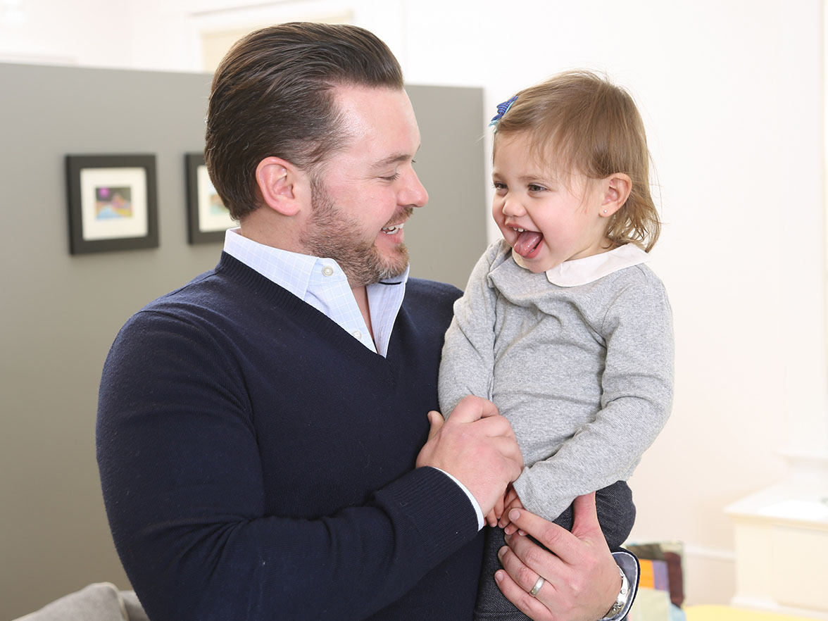 Father holding his child and makes silly faces