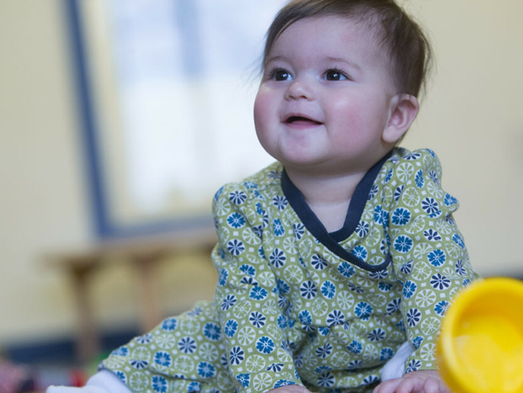 Infant smiling at teacher at Bright Horizons day care center