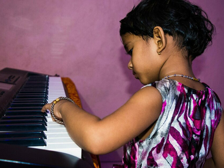 Toddler playing the piano at Bright Horizons day care