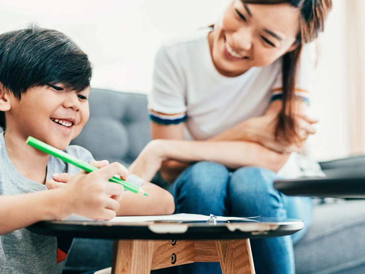 Preschooler at home reading a book and reflecting with mother 