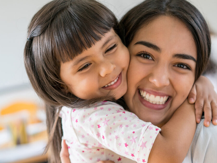 Mother and Daughter hugging each other and smiling 