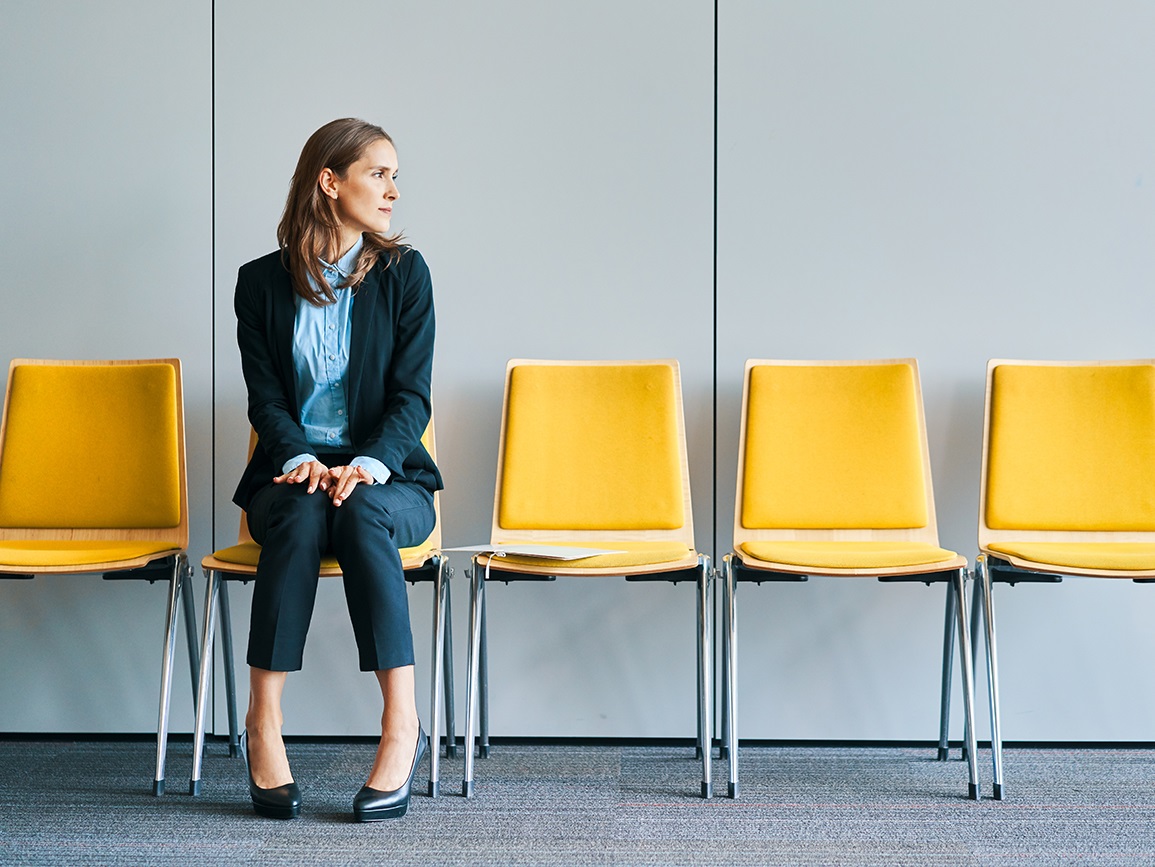 woman sitting alone on a set of yellow chairs