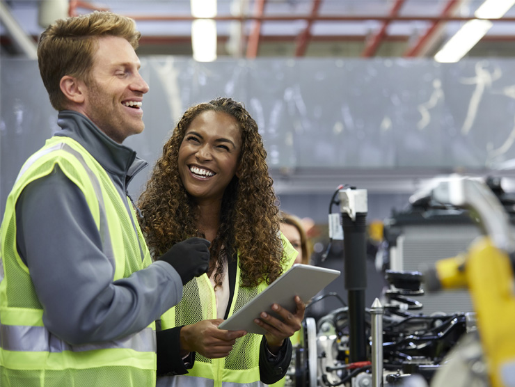 A man and woman in a factory looking at a tablet