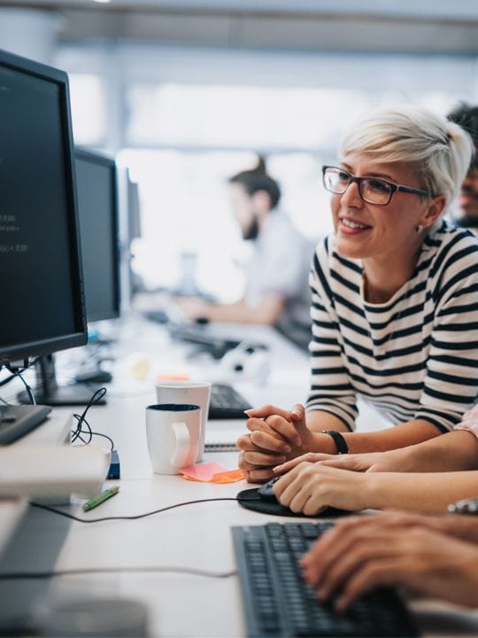 tech workers looking at computer screen