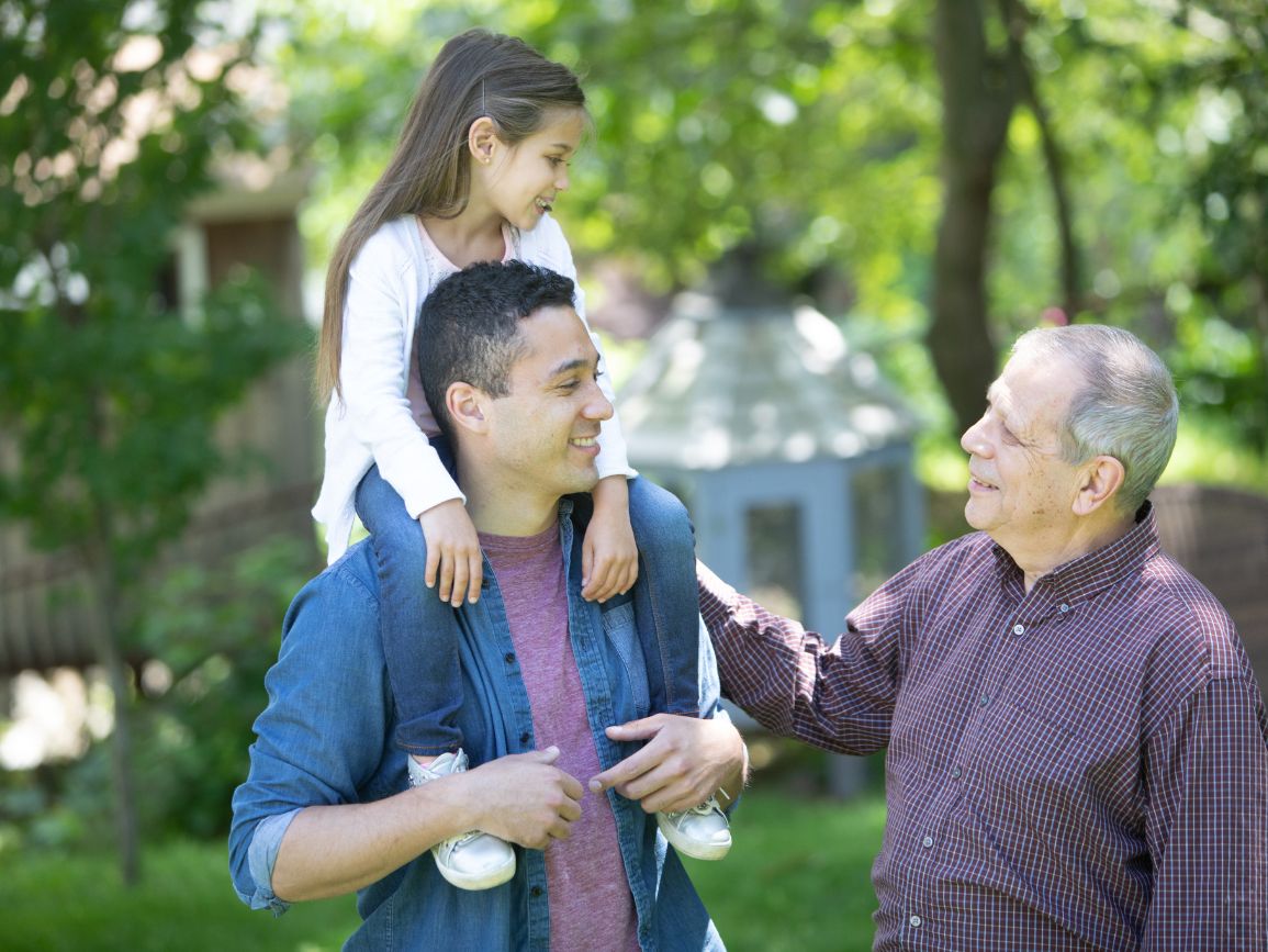 father with daughter on his shoulders meeting grandfather