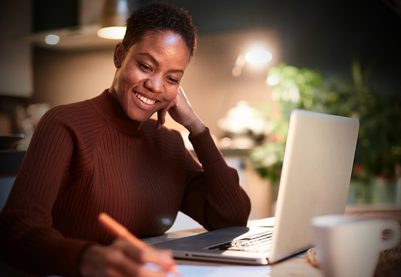 Young Black employee using education assistance at night