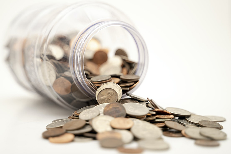 Overturned jar with coins spilling out