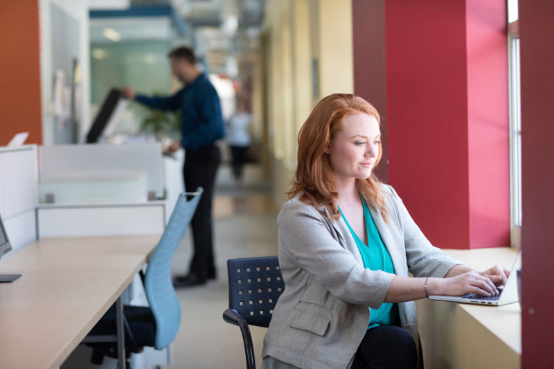 Burned out employee working while thinking about financial burdens