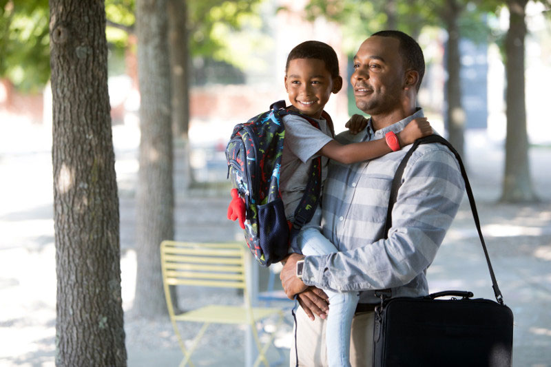 Working dad holding his preschool son