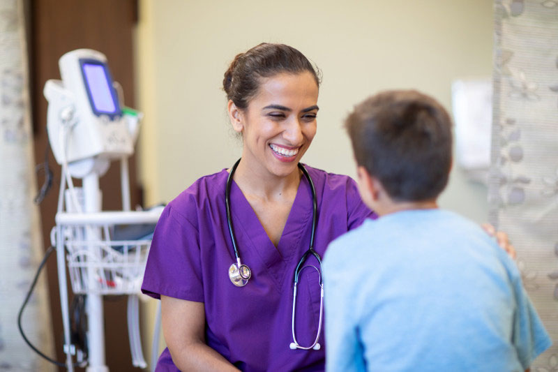 Female nurse assisting young boy in a hospital