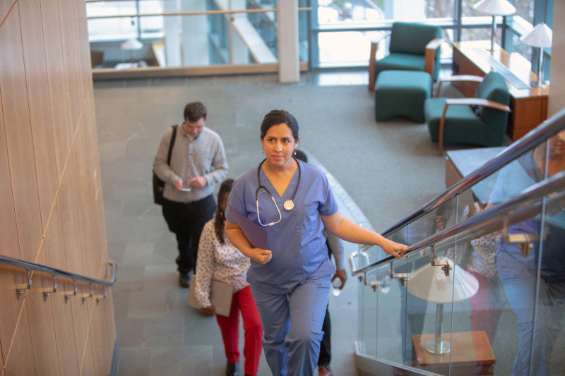 Pregnant nurse walking up the hospital stairs