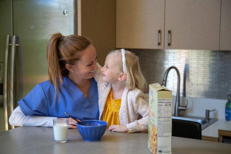 Nurse and working mom eating breakfast with her daughter