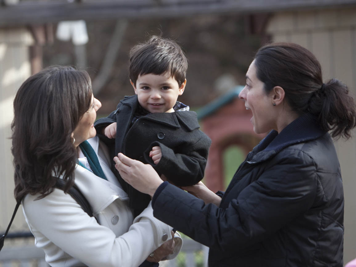 A mother with her child and their child care teacher