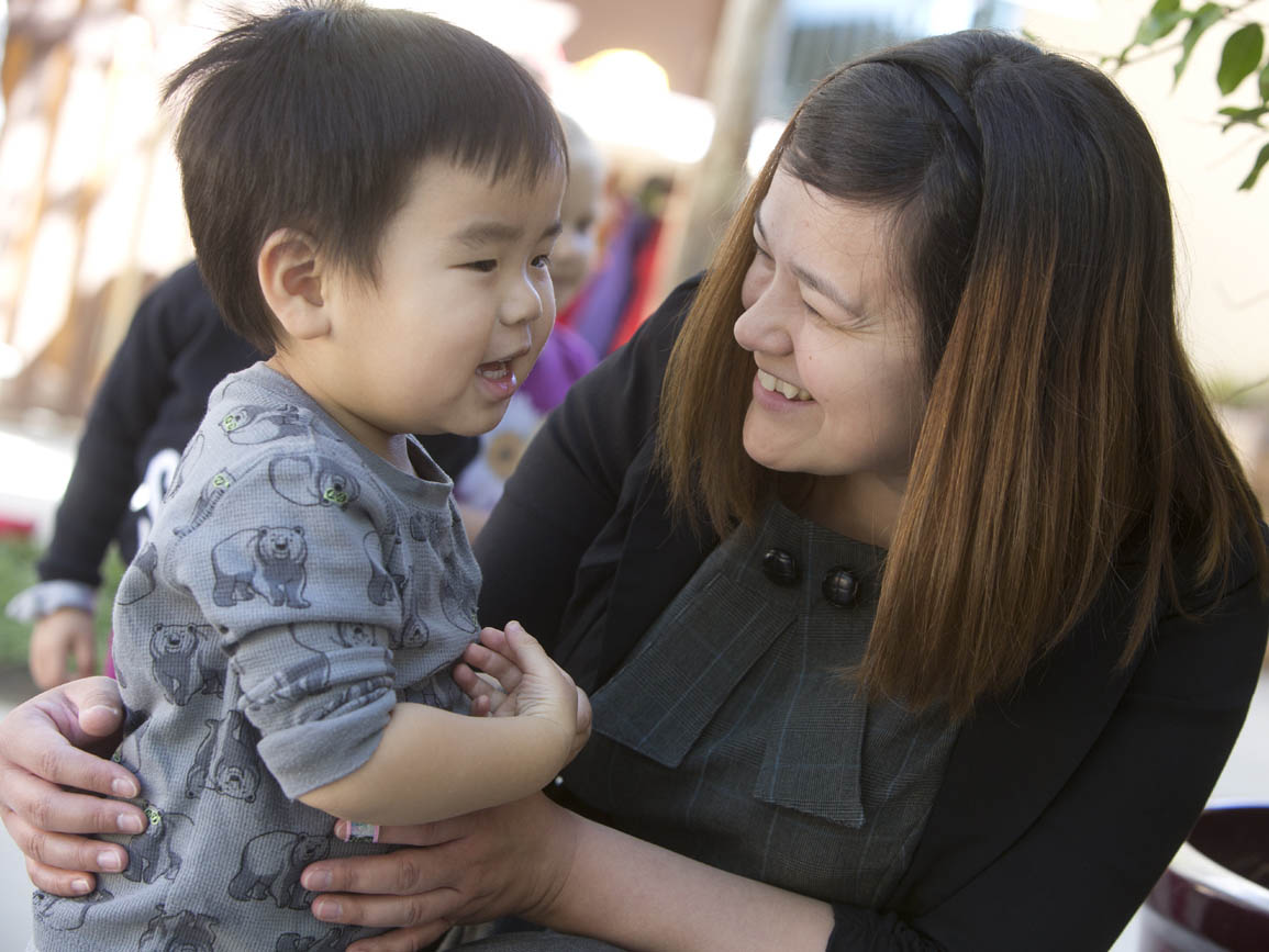 Mom kneeling down to talk to toddler boy