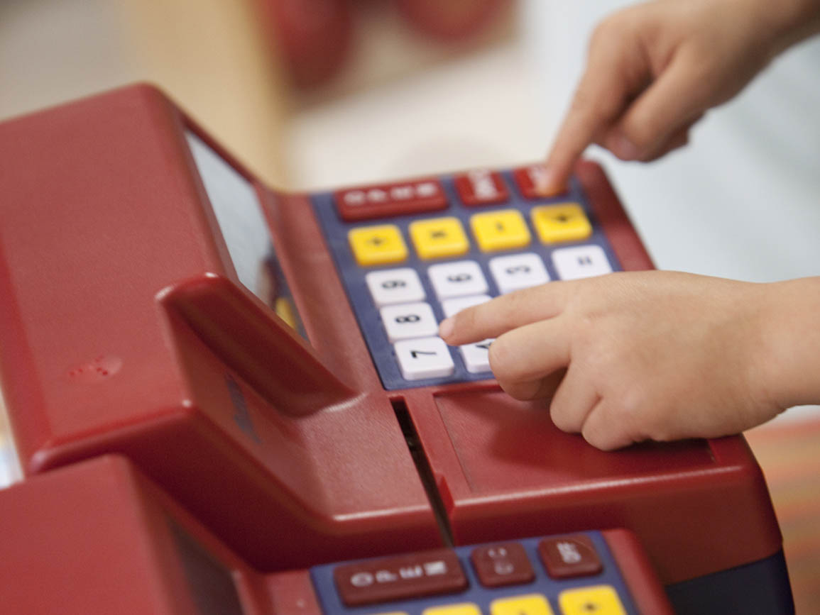 Kid's fingers on a cash register