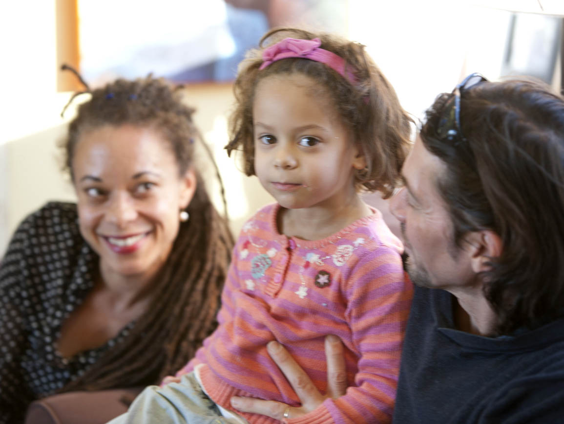 Preschool girl sitting with mom and dad