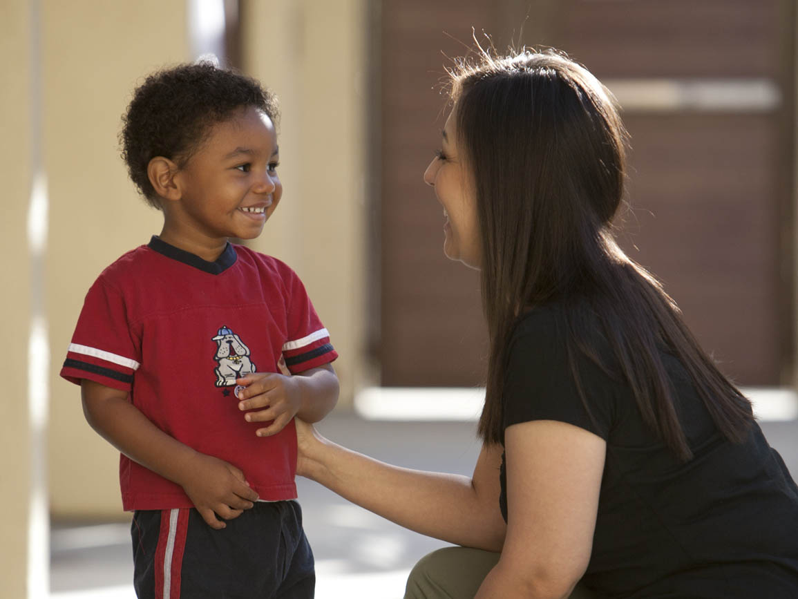 Preschool boy smiling at woman