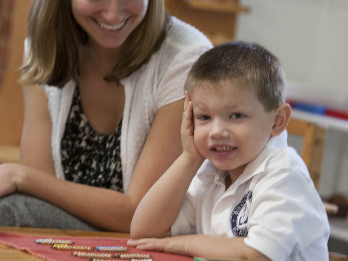 Preschool boy sitting at a table with his mom