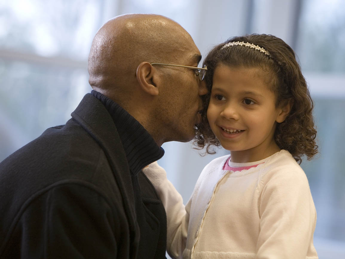 Dad whispering to his daughter