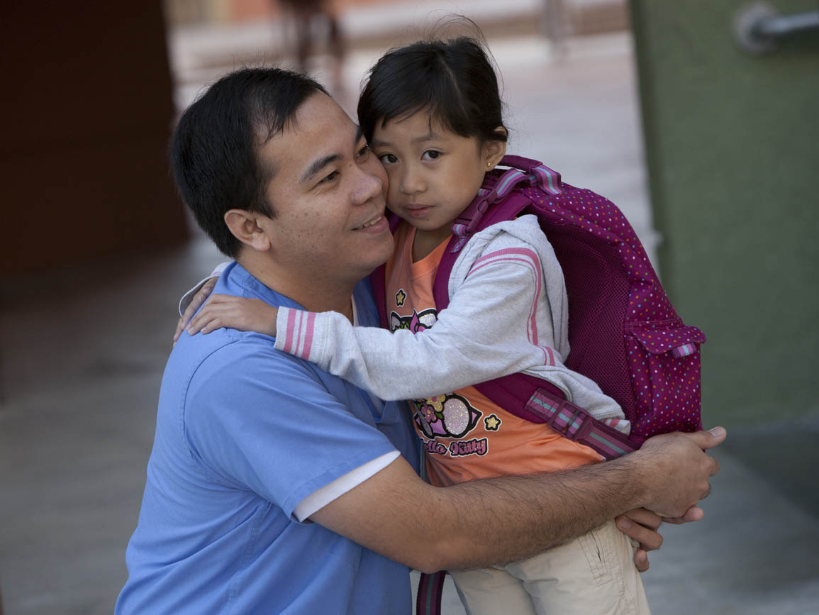 a shy child hugging dad