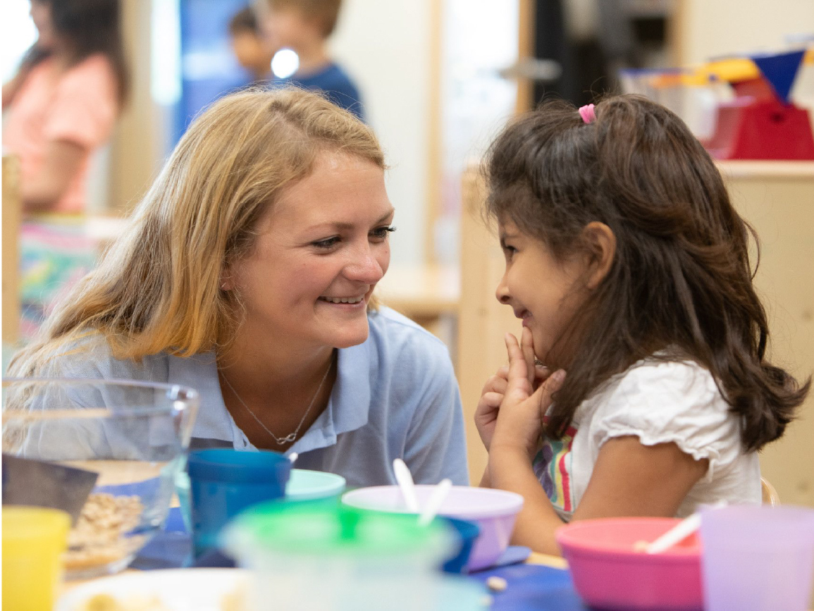 Child care worker with child smiling