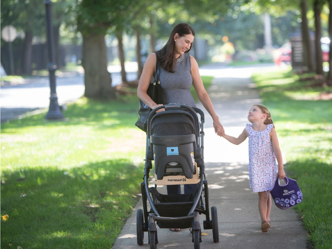 Woman walking with stroller and child