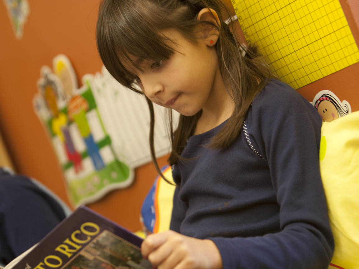 Young girl sitting and reading a book