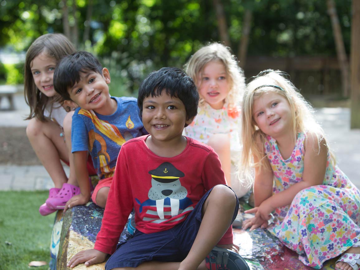 Diverse group of young kids sitting together outside