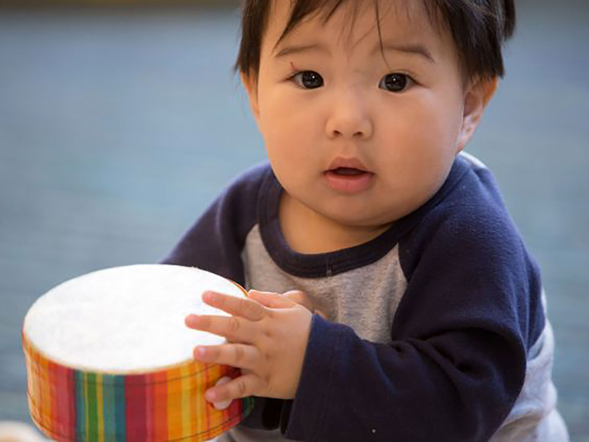 Baby playing a drum