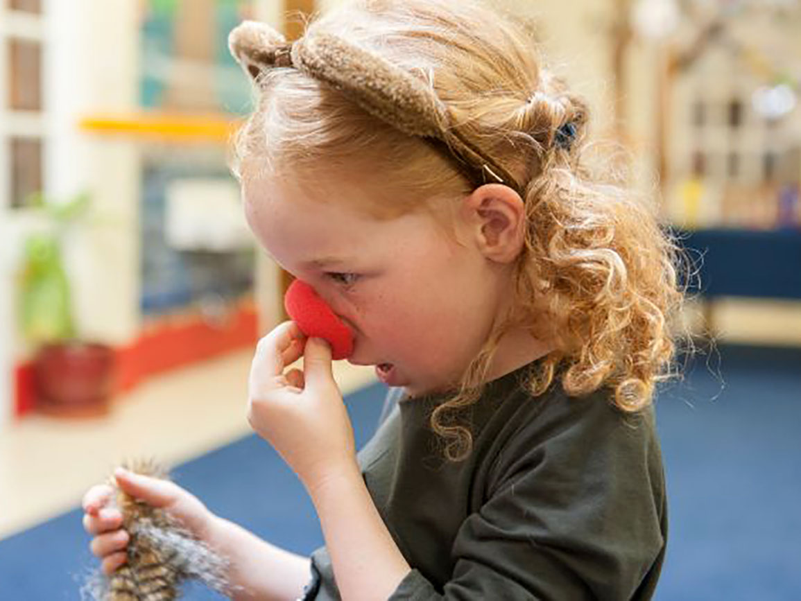 Kindergarten-aged girl playing dress up