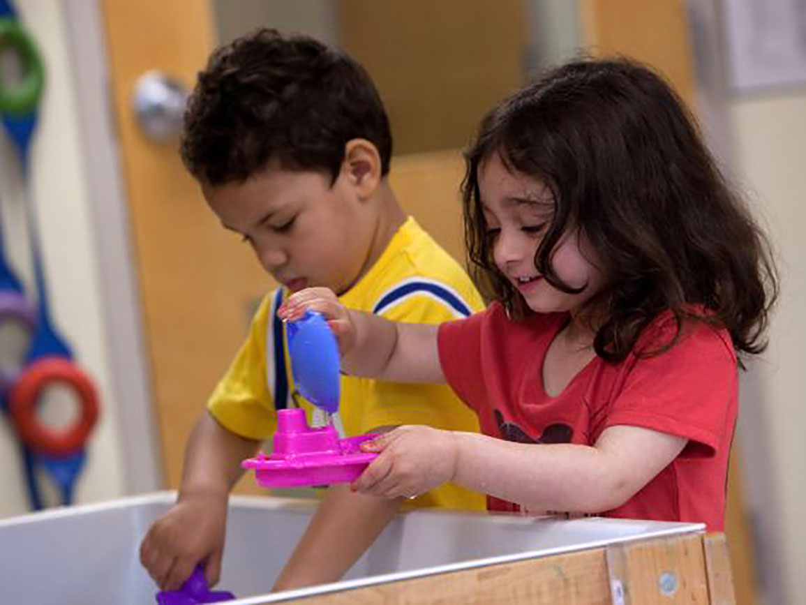 Kindergartners playing with boats