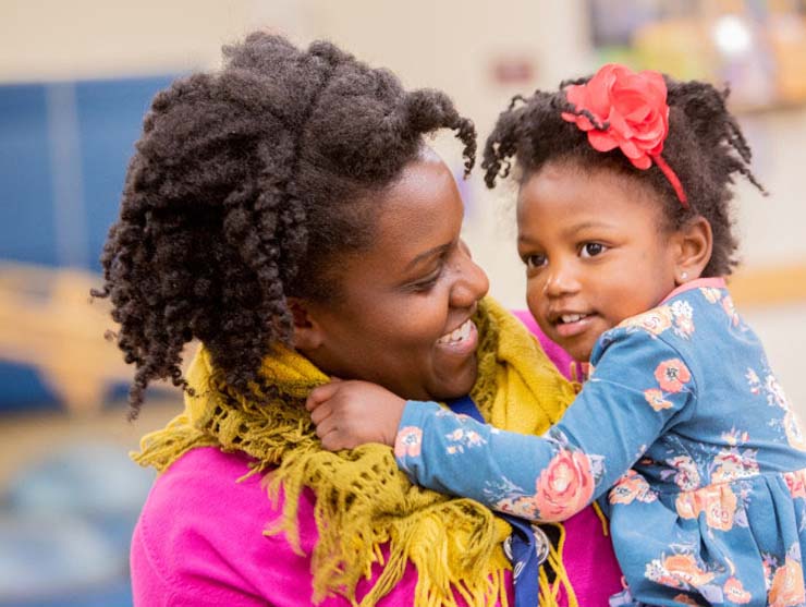 Mom picking up young daughter from center-based child care